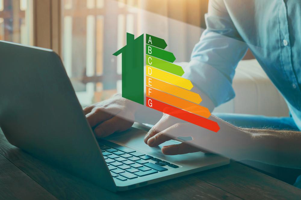 Uomo al computer con visualizzata l'immagine della scala di classificazione dell'efficienza energetica