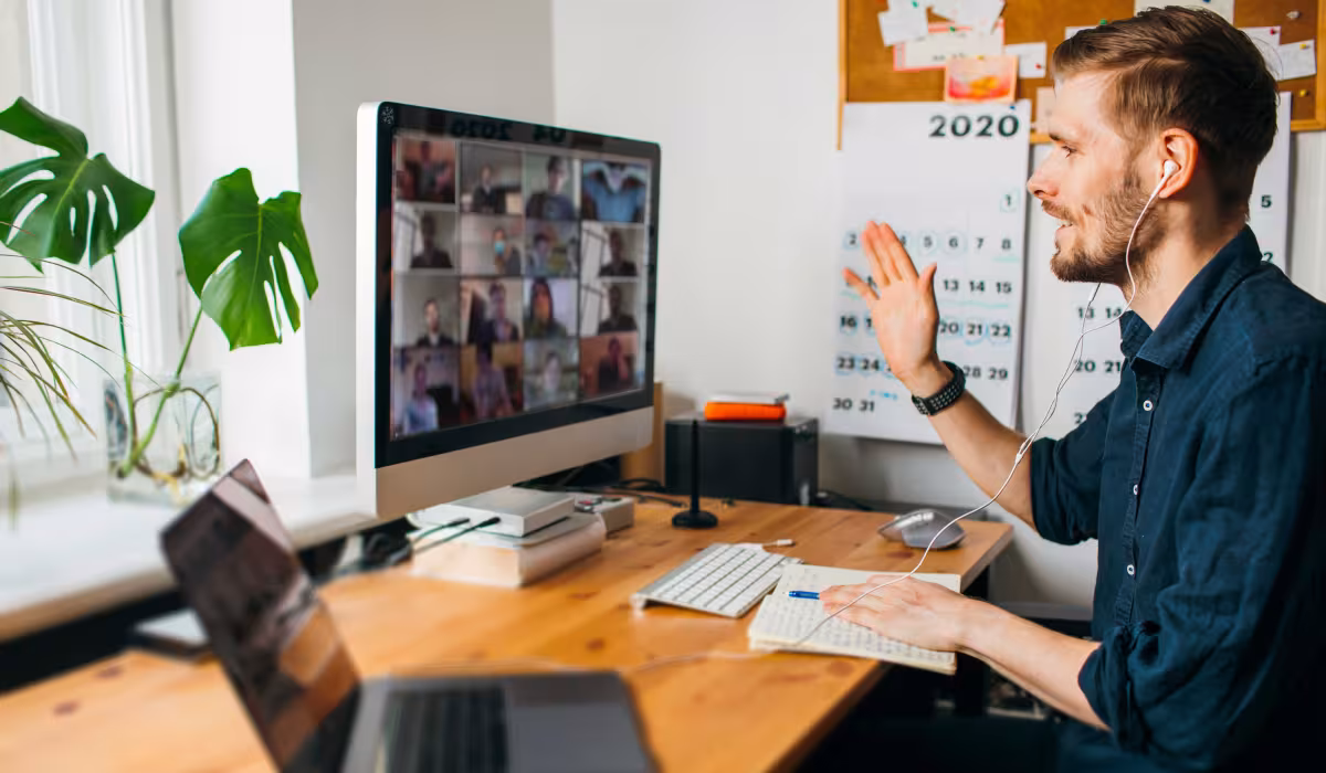Uomo in smart working a casa durante una riunione online con i colleghi al computer