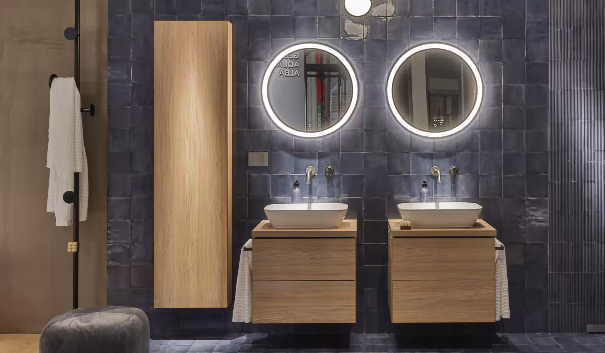 Bagno Geberit Experience Center con doppio lavabo, specchi retroilluminati e placca Living NOW di BTicino