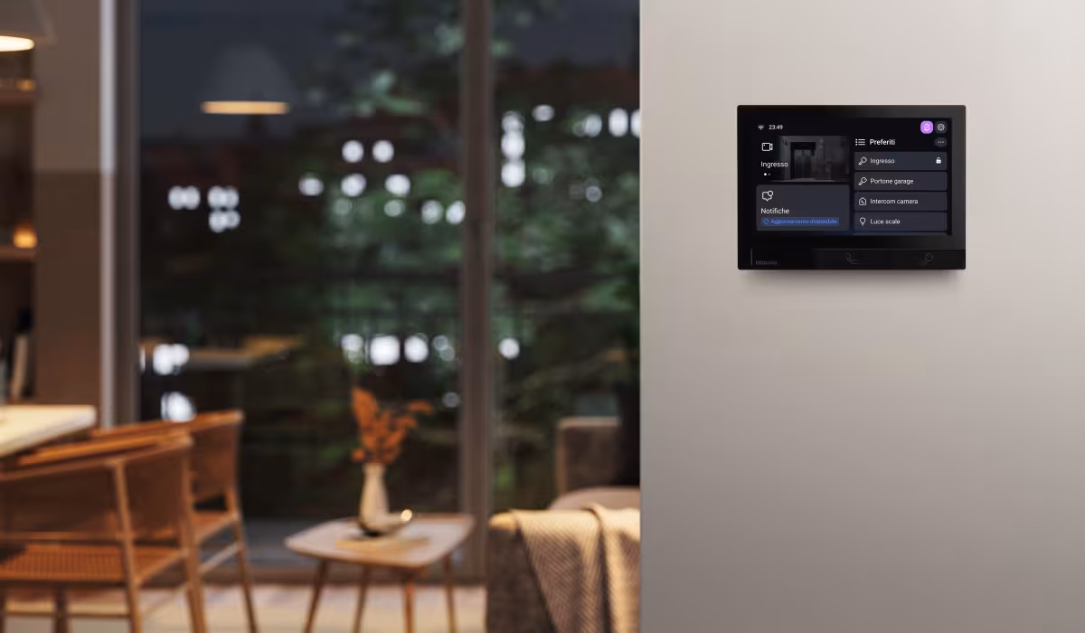 Ambientazione serale in un soggiorno con videocitofono Classe 300X nero installato a parete
