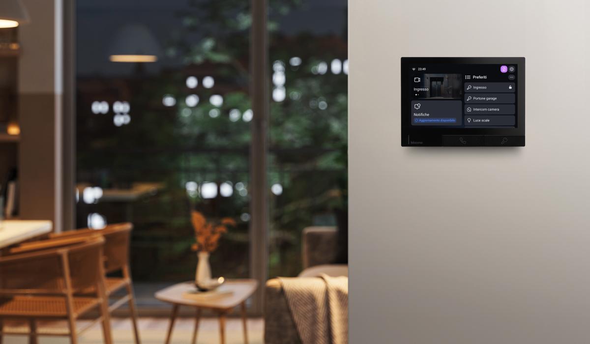 Ambientazione serale in un soggiorno con videocitofono Classe 300X nero installato a parete