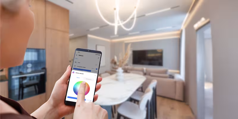 Persona che controlla le luci della cucina tramite app Home + Control di BTicino