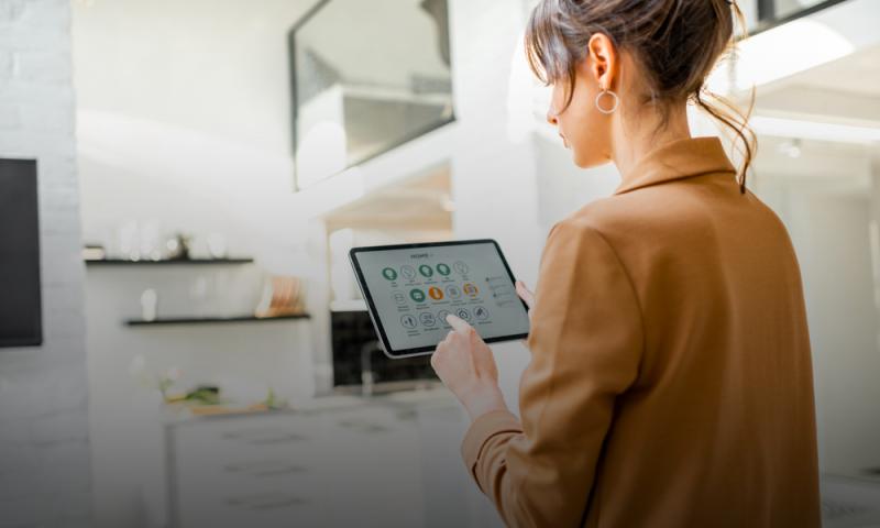 Donna che controlla gli elettrodomestici smart tramite tablet