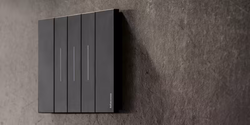 Placca Living Now BTicino nera installata su parete effetto cemento dal design moderno