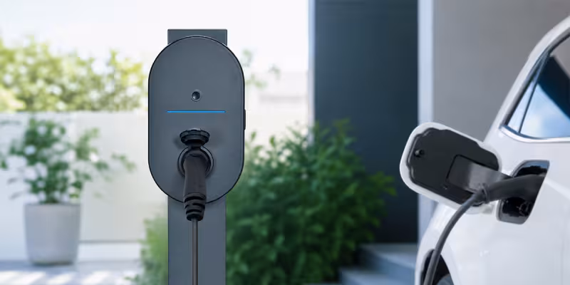 Colonnina di ricarica Green'up Home BTicino su palo in giardino, collegata a un'auto elettrica