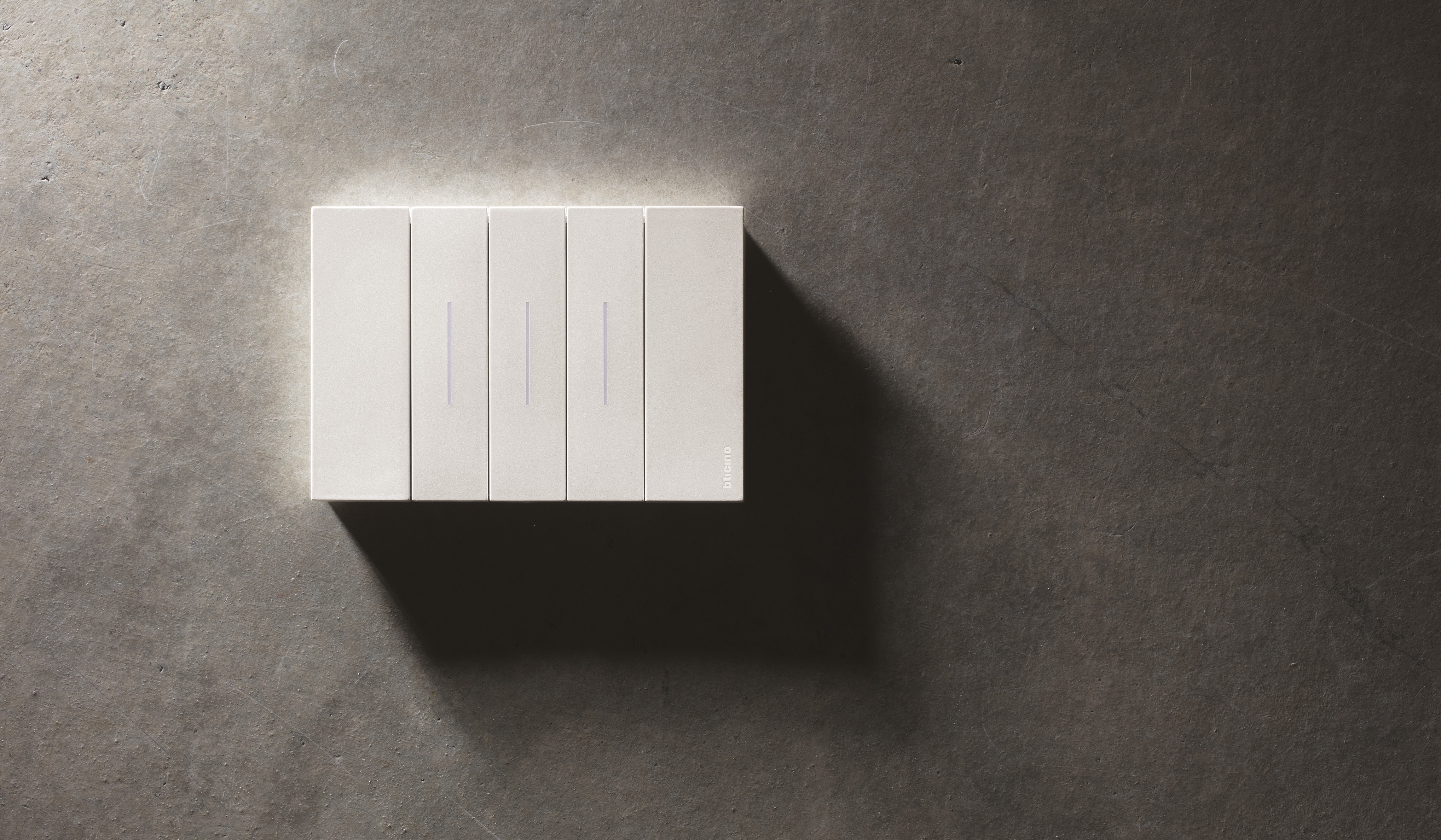 Placca Living NOW Monochrome BTicino su parete scura con illuminazione soffusa