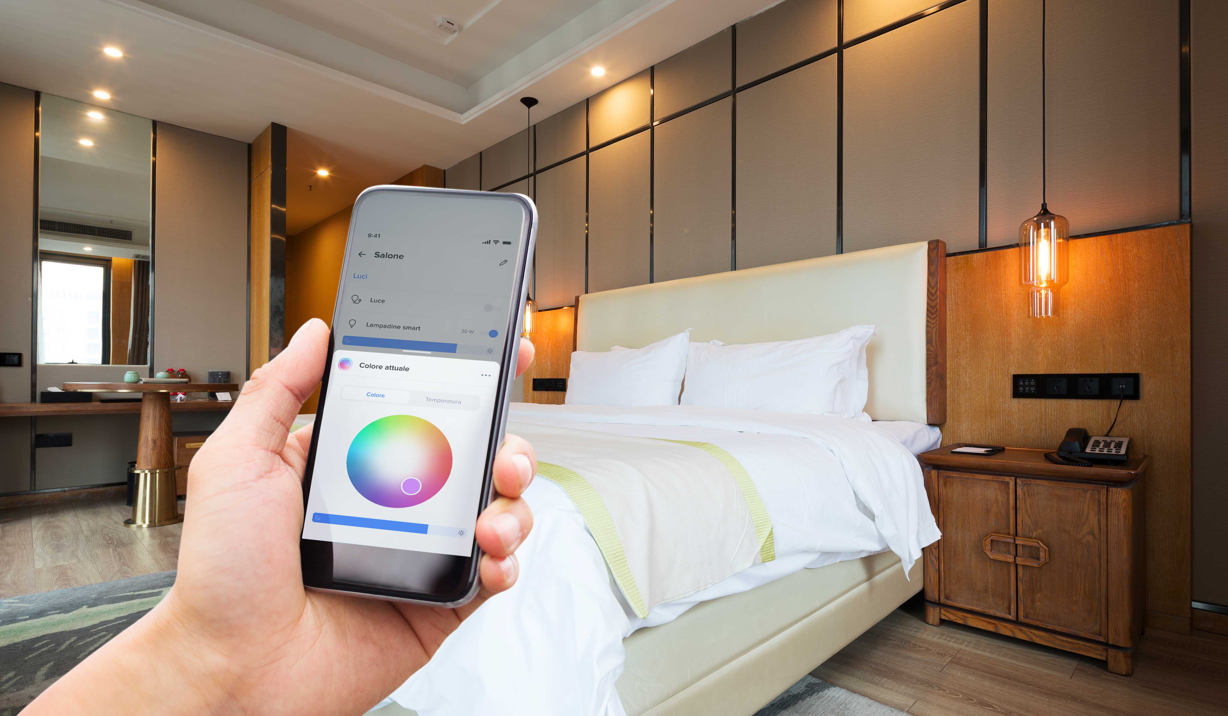 Illuminazione ideale Uomo con in mano smartphone con schermata per il controllo luci dell'app Home + Control di Bticino