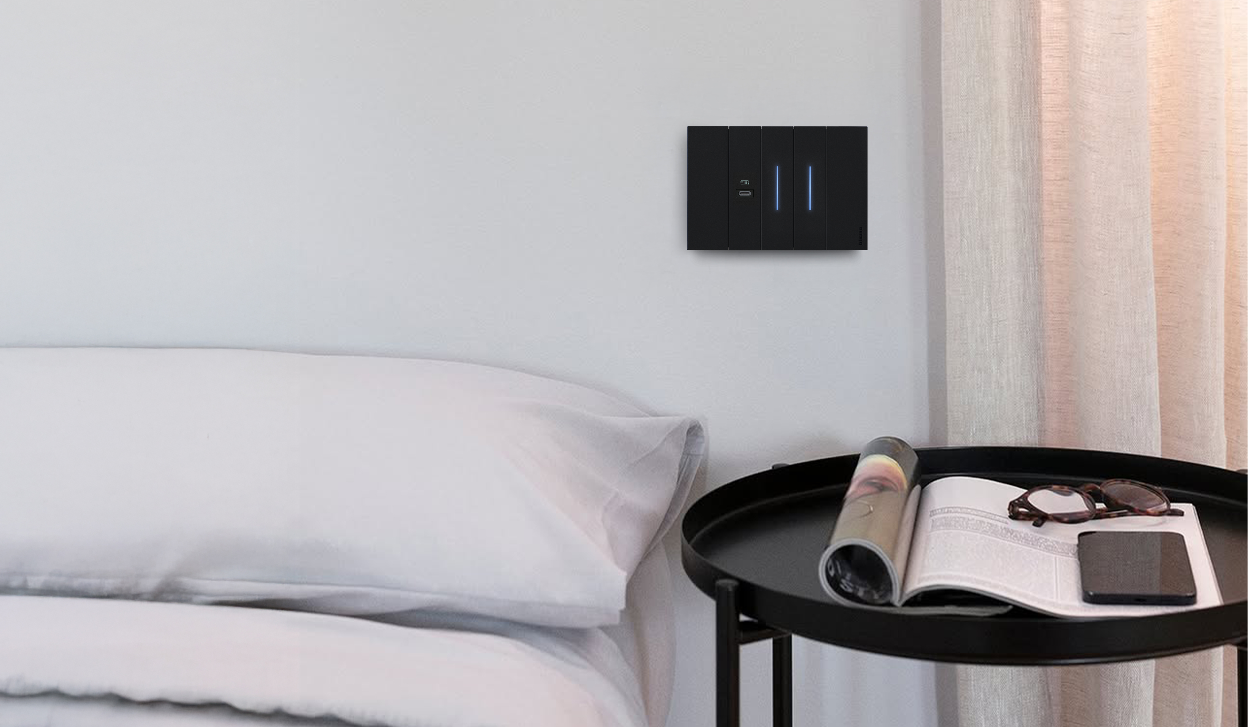 Placca Living Now con comando luci e presa usb-c Placca Bticino Living Now con presa usb-c e comando luce posizionata sopra il comodino e il letto