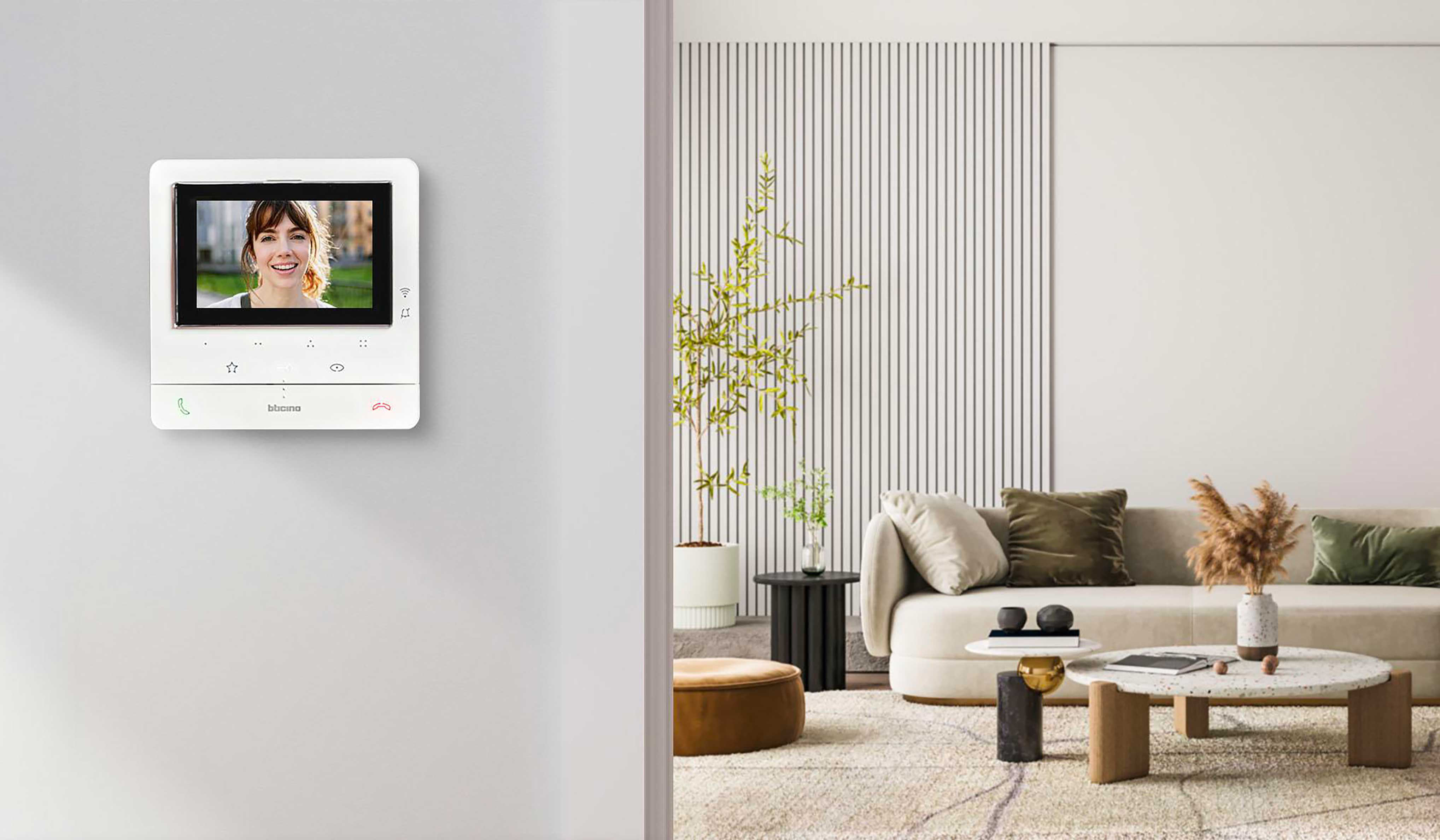 Videocitofono connesso Classe 100X Smart BTicino a parete con schermo acceso in un soggiorno moderno e luminoso