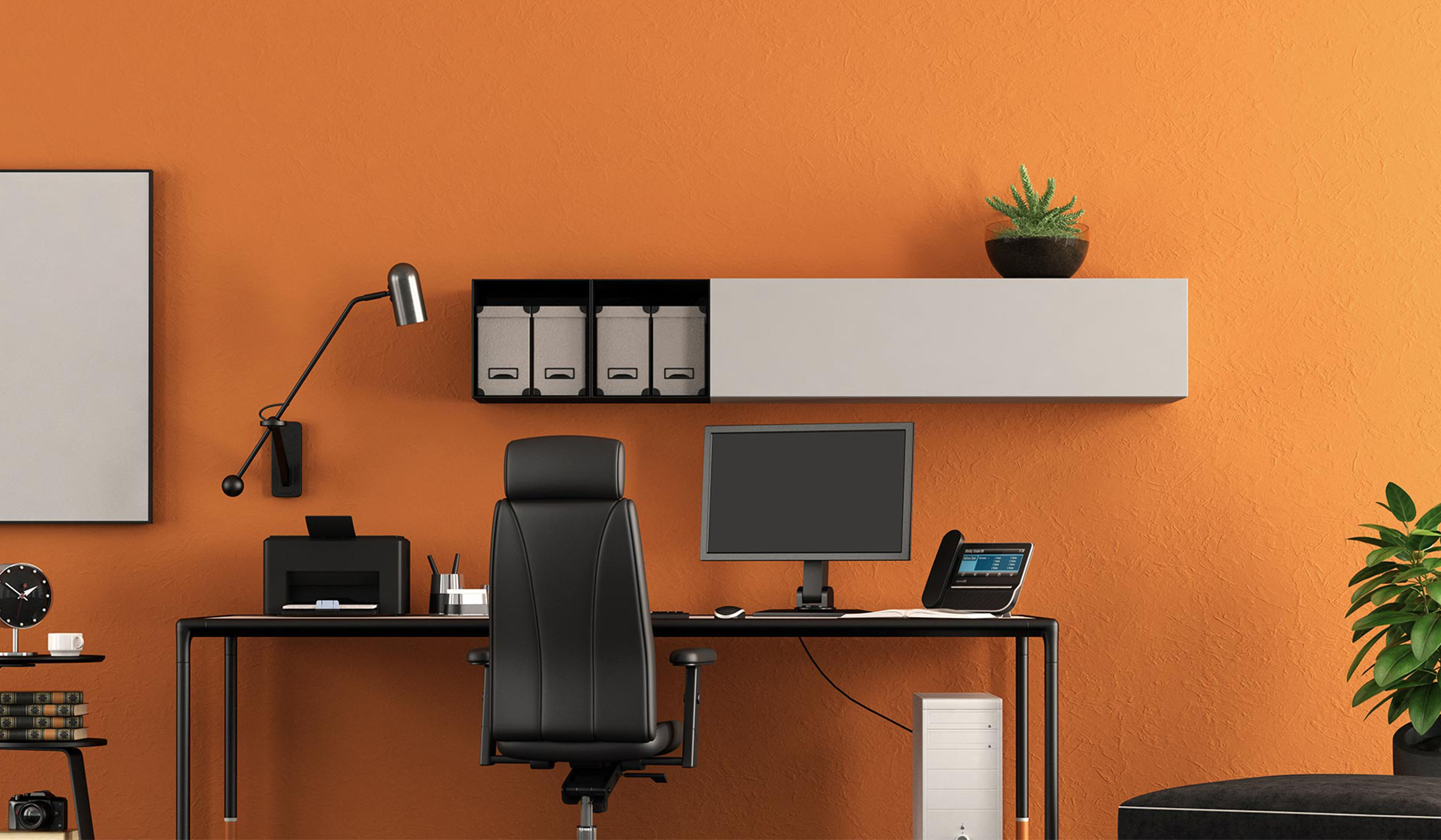 Ufficio con parete arancione, scrivania con monitor e telefono, sedia, lampada da tavolo e mensola con contenitori e pianta