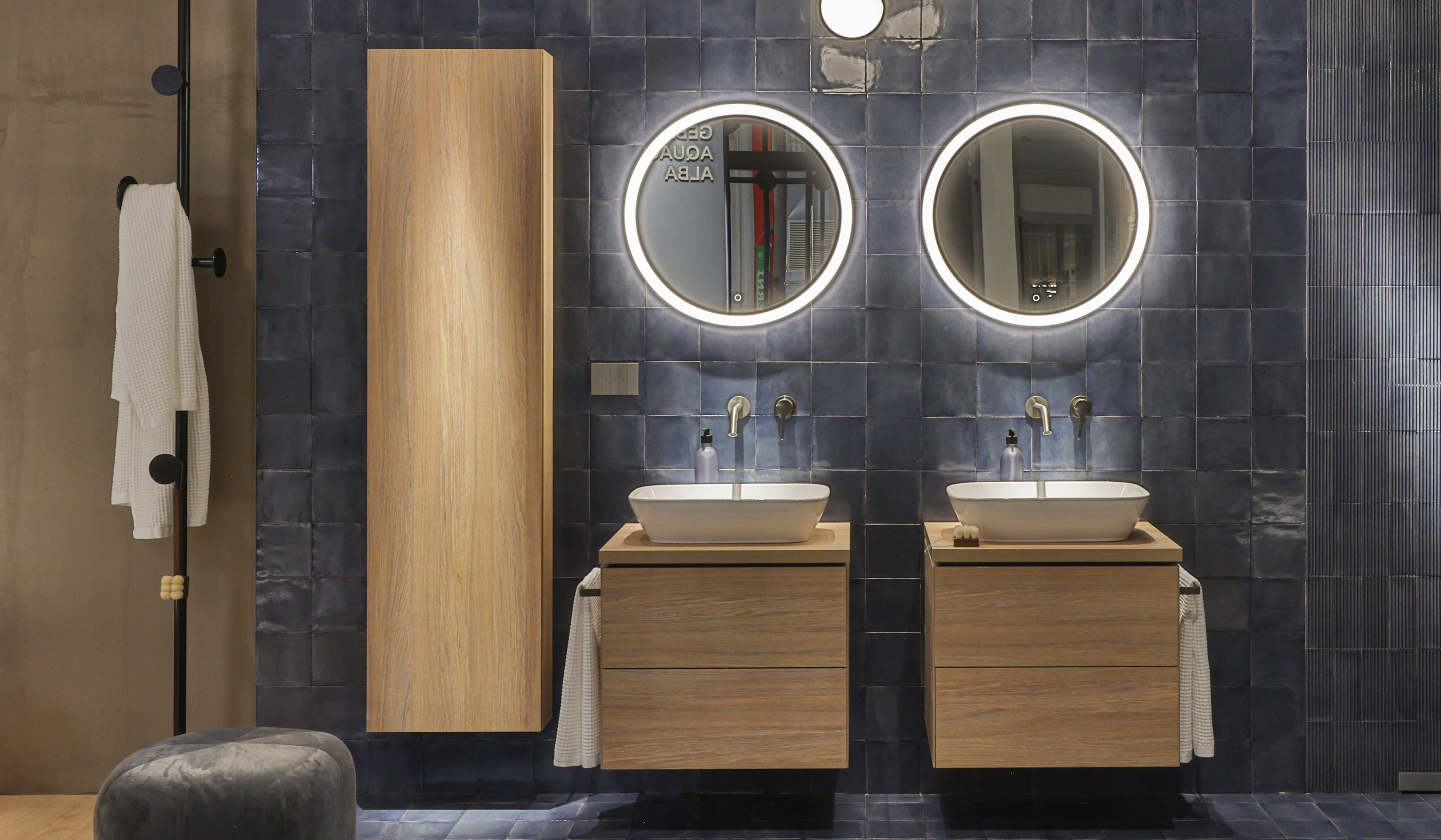 Bagno Geberit Experience Center con doppio lavabo, specchi retroilluminati e placca Living NOW di BTicino