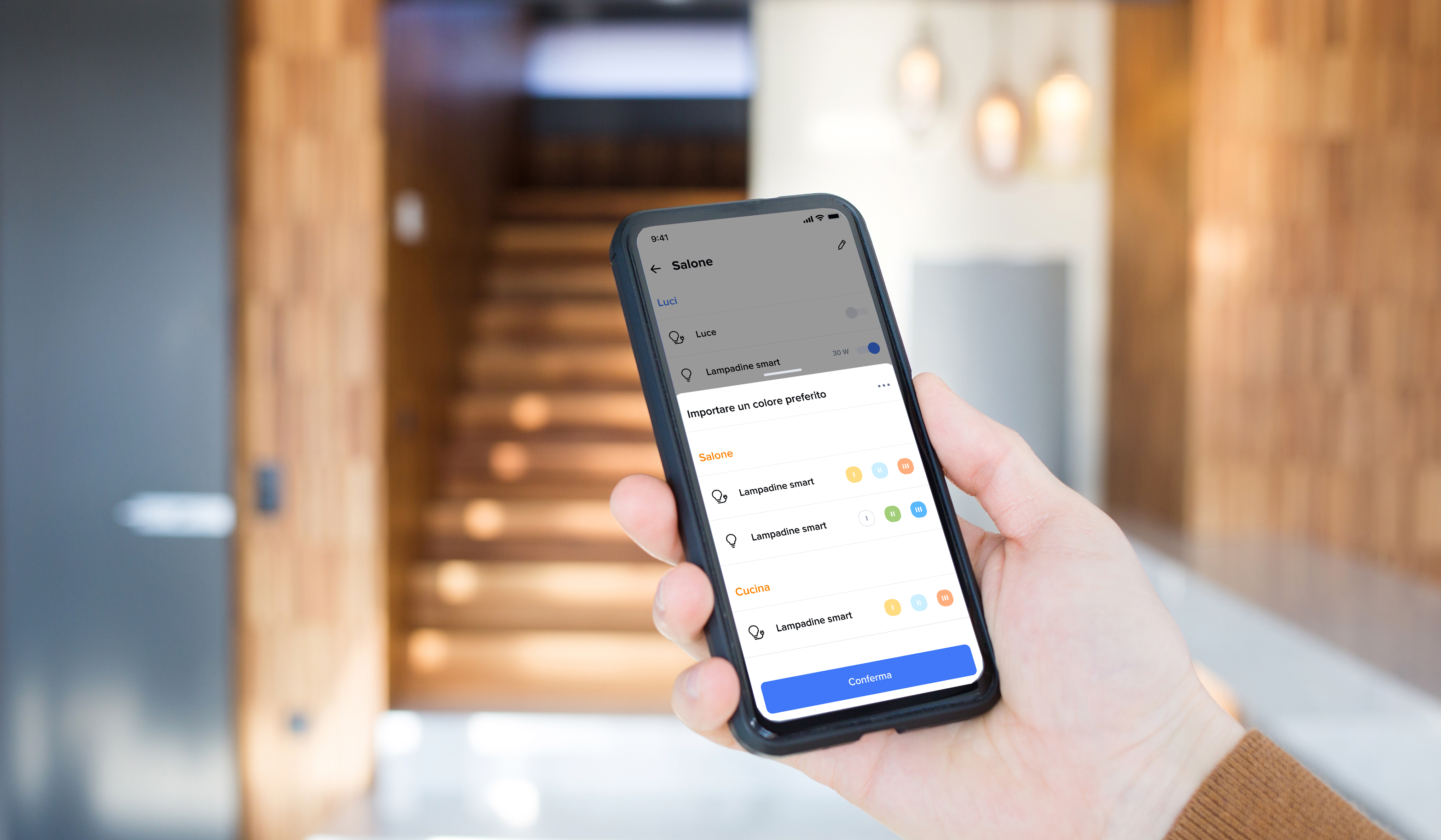 Persona che tiene in mano uno smartphone con l’app Home + Control di BTicino aperta per controllare le luci smart della casa